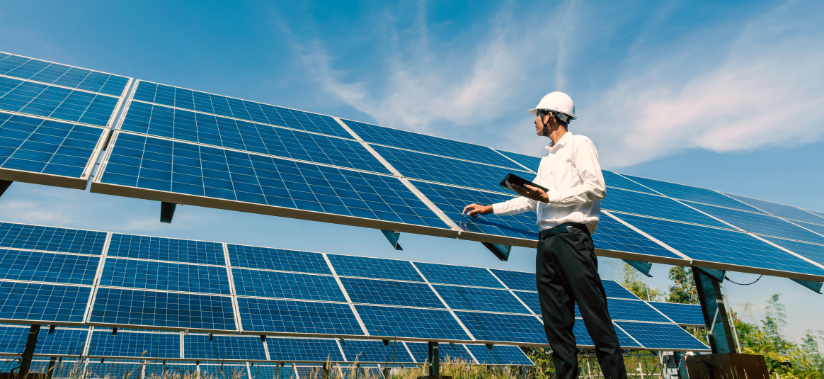 Hard hat employee reviewing solar panels