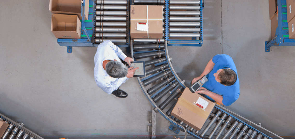 aerial view of workers using barcode scanner and iPad on packing conveyor belt 