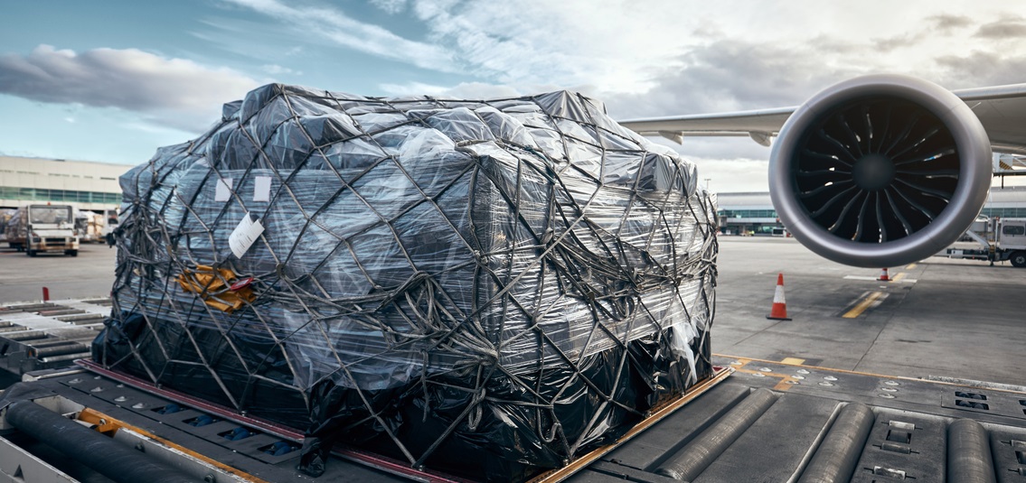 pallet of air freight, next to jet on runway