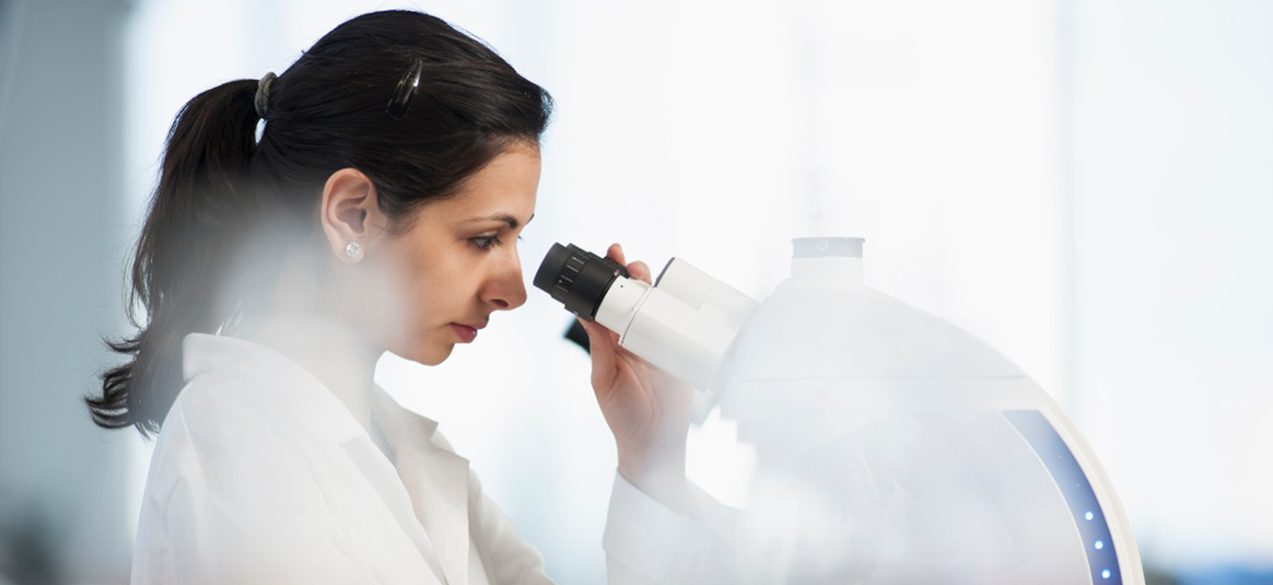 Photo of a person in a laboratory using a stereo microscope