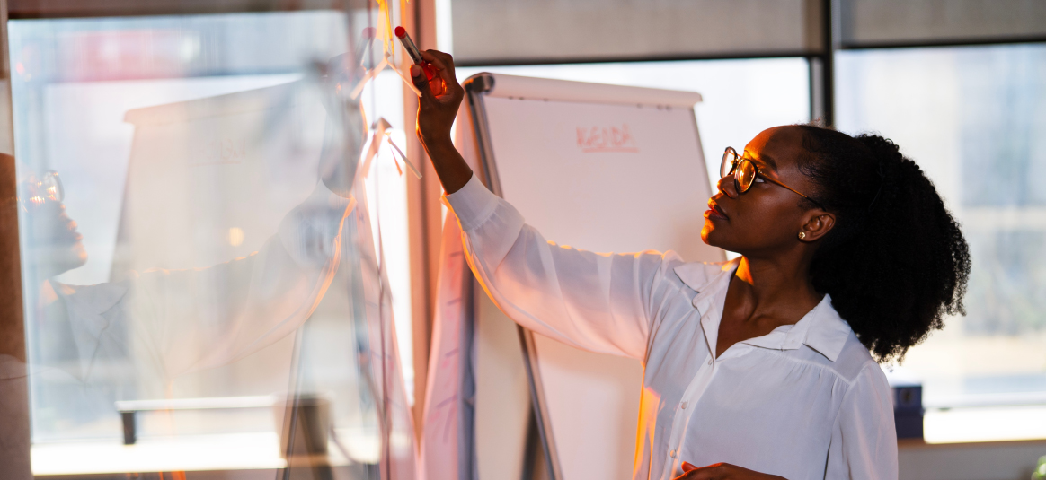 Photo of a person writing on an office window