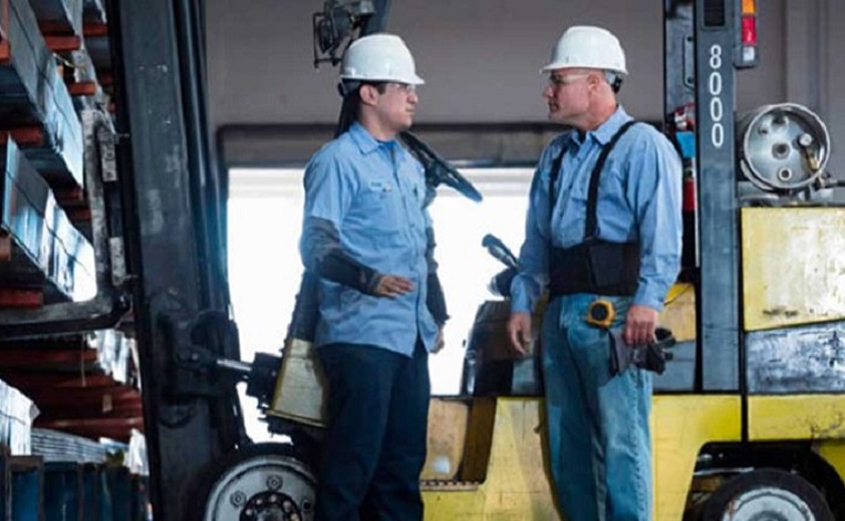 Two workers in overalls in a factory
