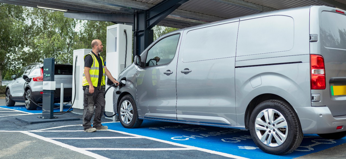 Photo of a person plugging in a van to charge