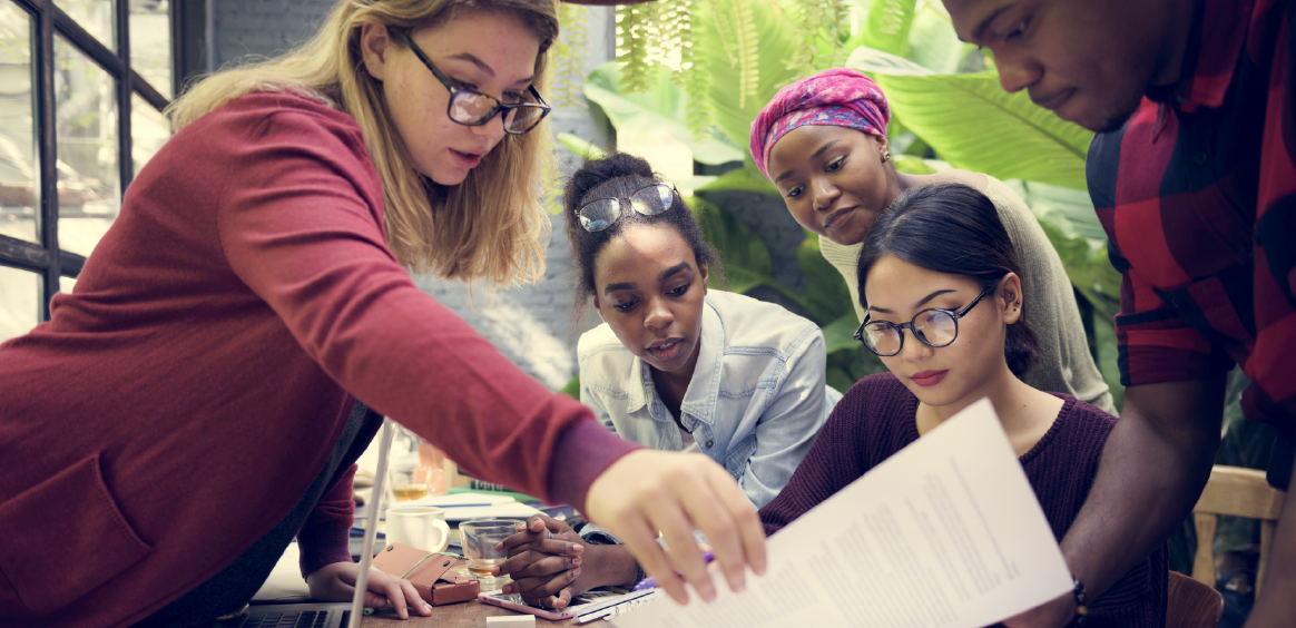 Photo of students around a table with a teacher