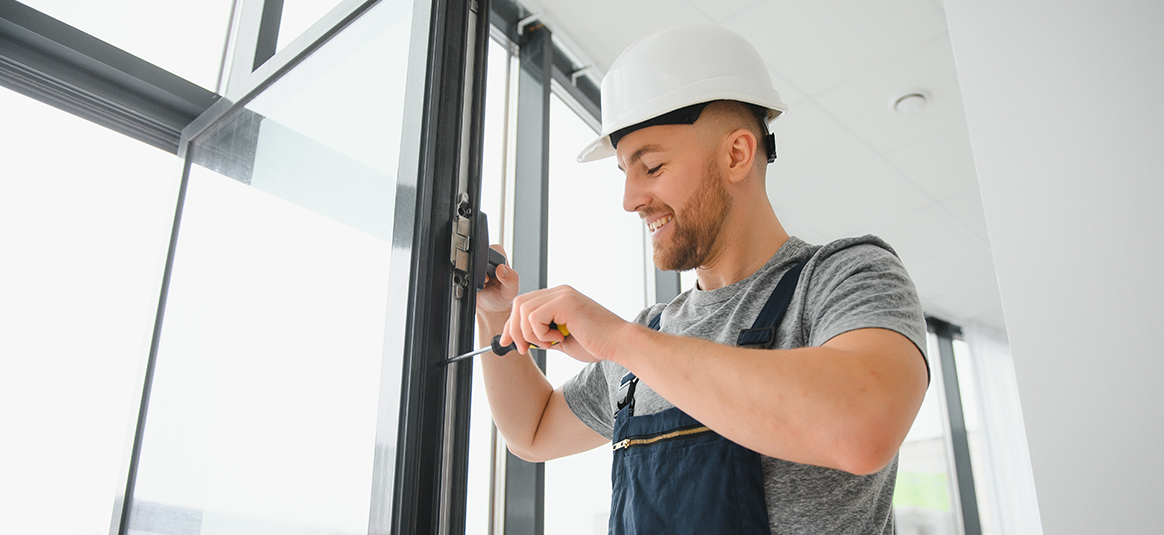 Photo of a worker fixing a window Photo of a worker fixing a window