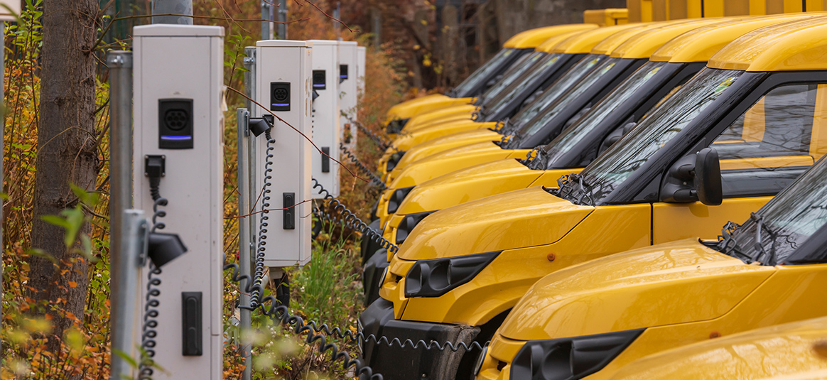 Photo of a fleet of electric vans at charging ports