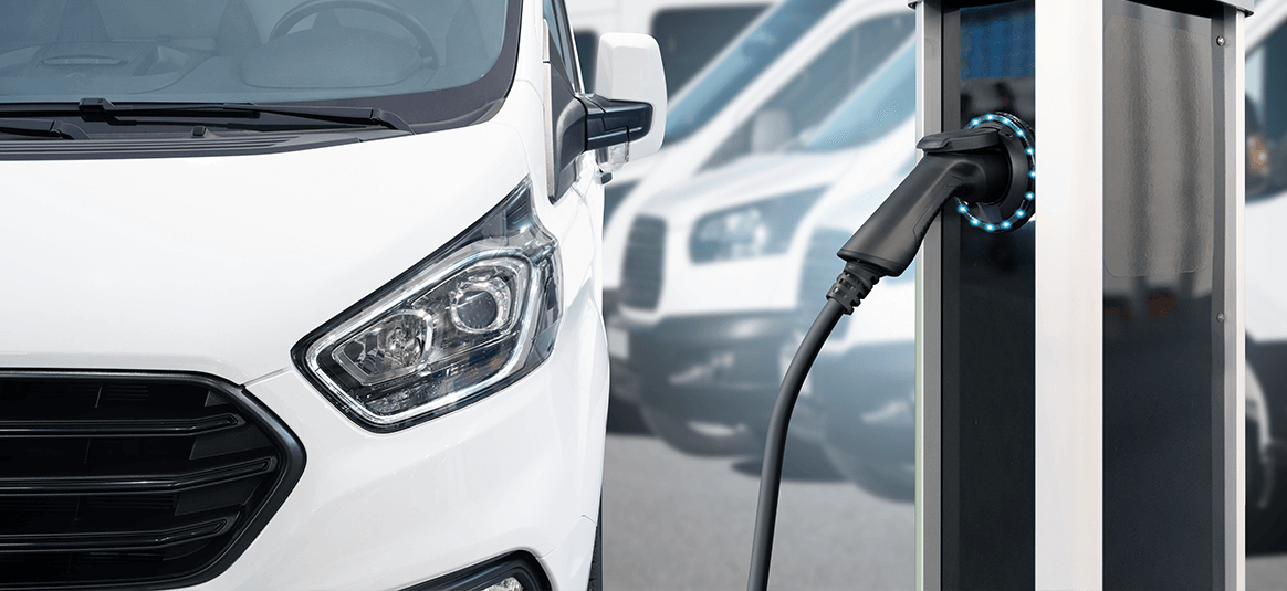 An electric white van at a charging port