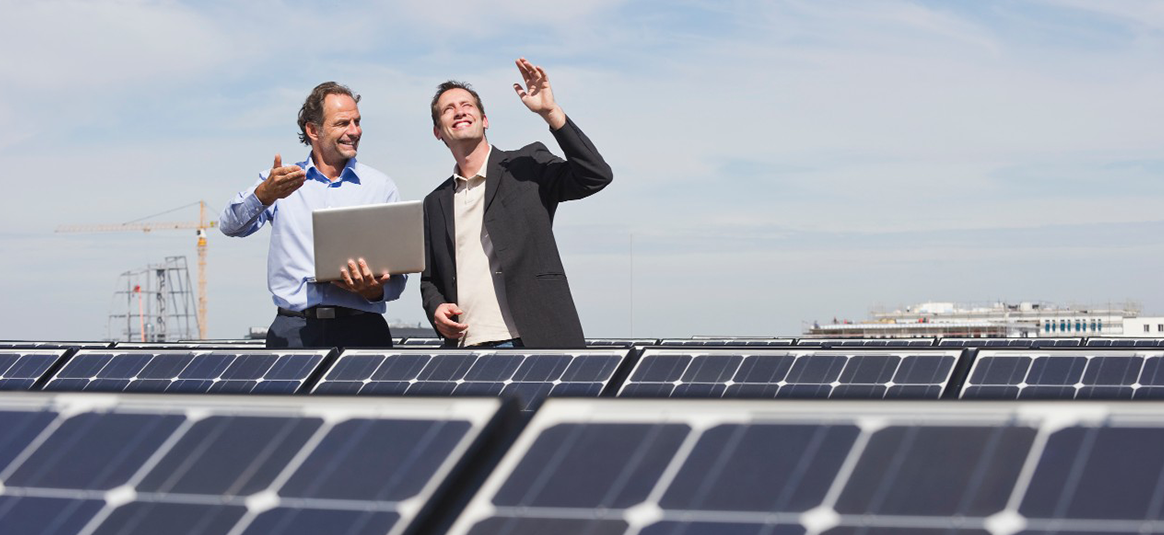 Workers walking near solar panels