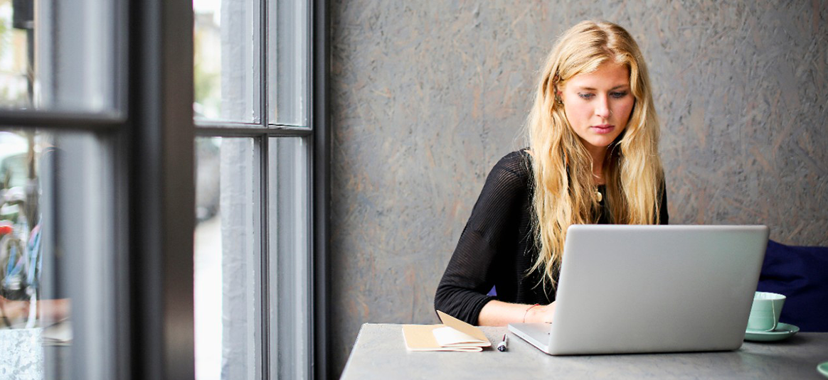 Woman on a laptop by the window 