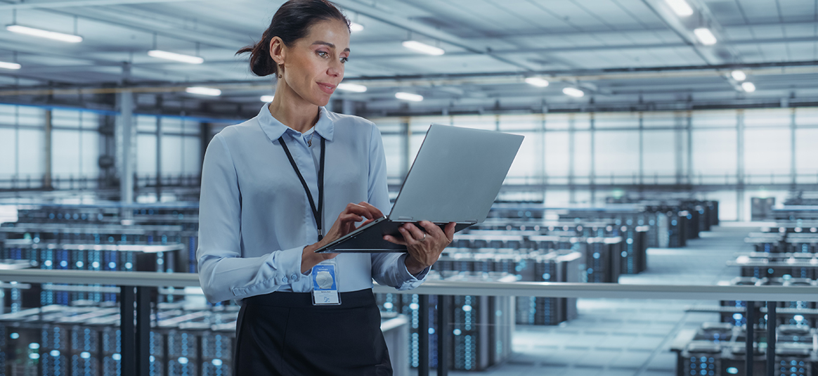 A worker in the server room on a laptop