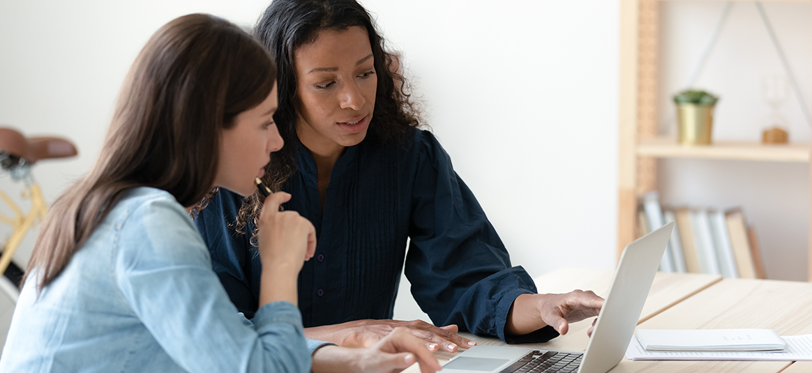 Two women discussing whats on the laptop screen 