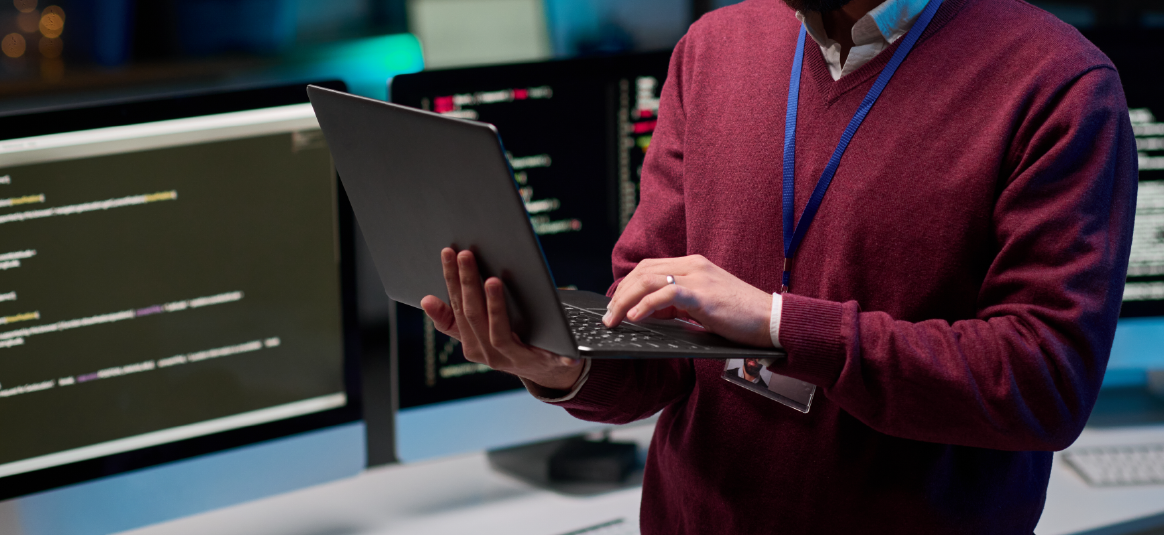 Photo of a person standing using a laptop computer