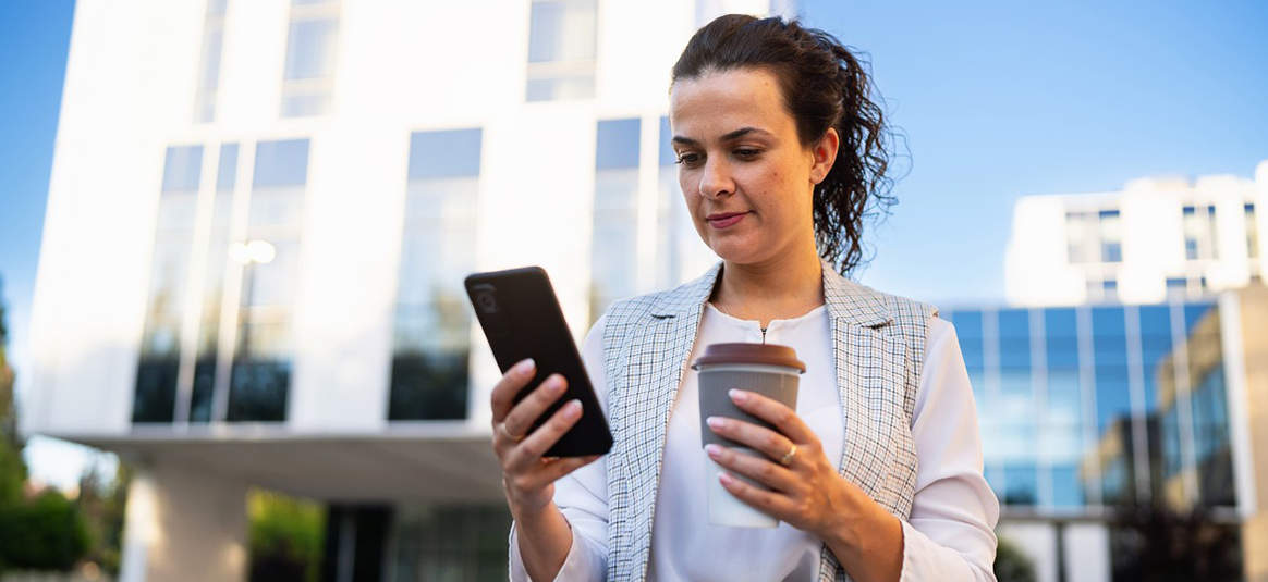 Photo of a person with a mobile phone and a drink