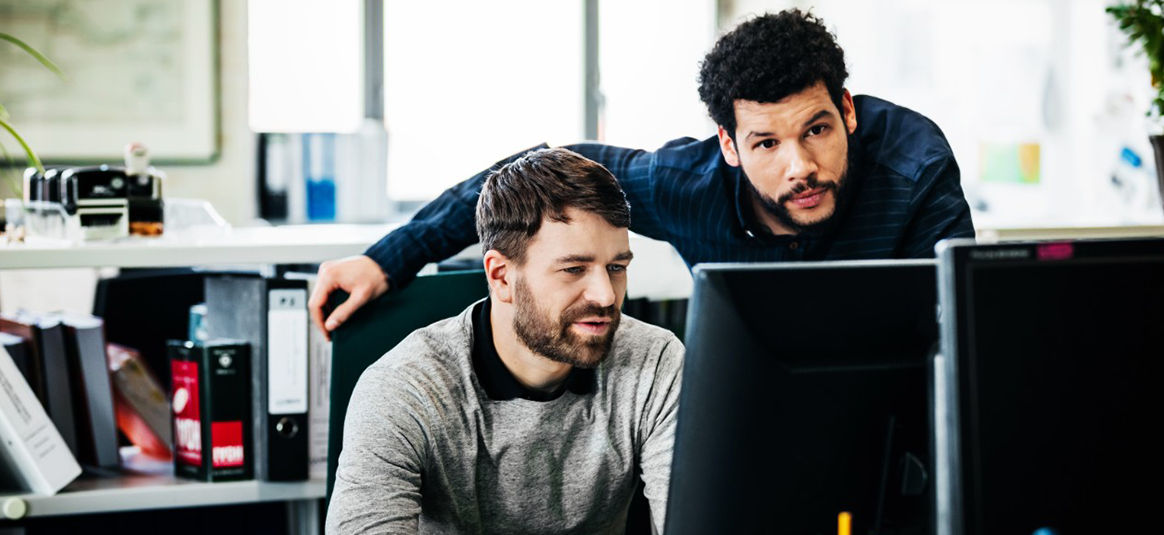 Photo of two people using a computer