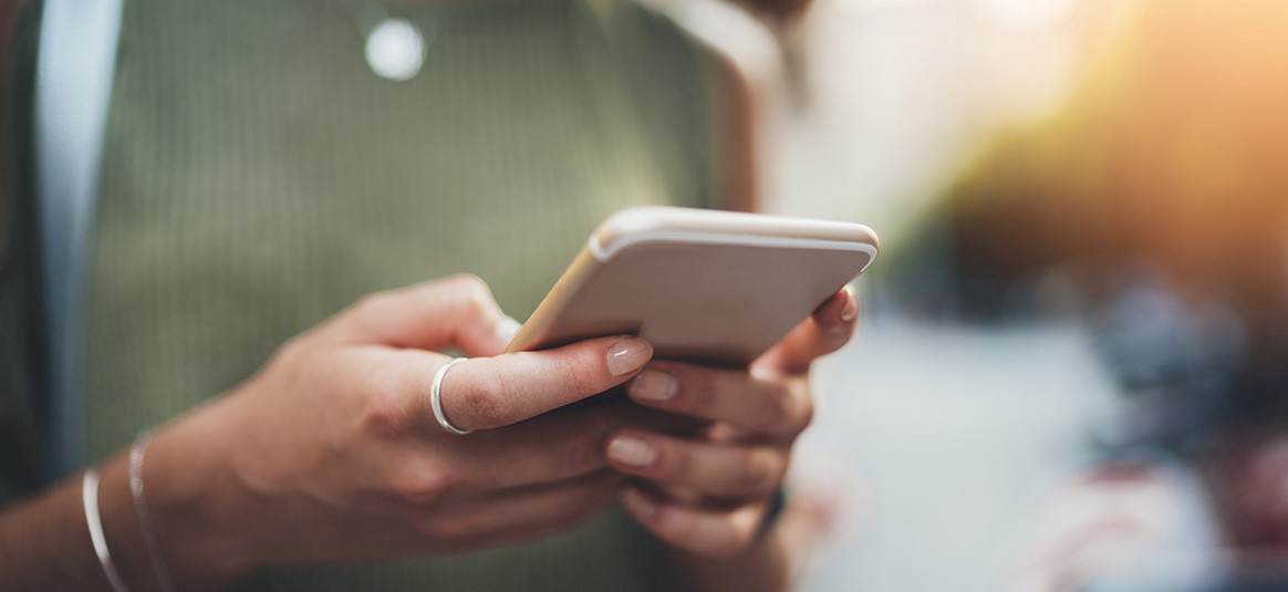 Photo of two hands holding a mobile phone. Photo of two hands holding a mobile phone.