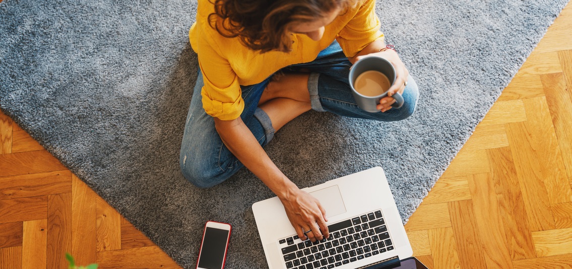 Woman cross legged on floor working on laptop