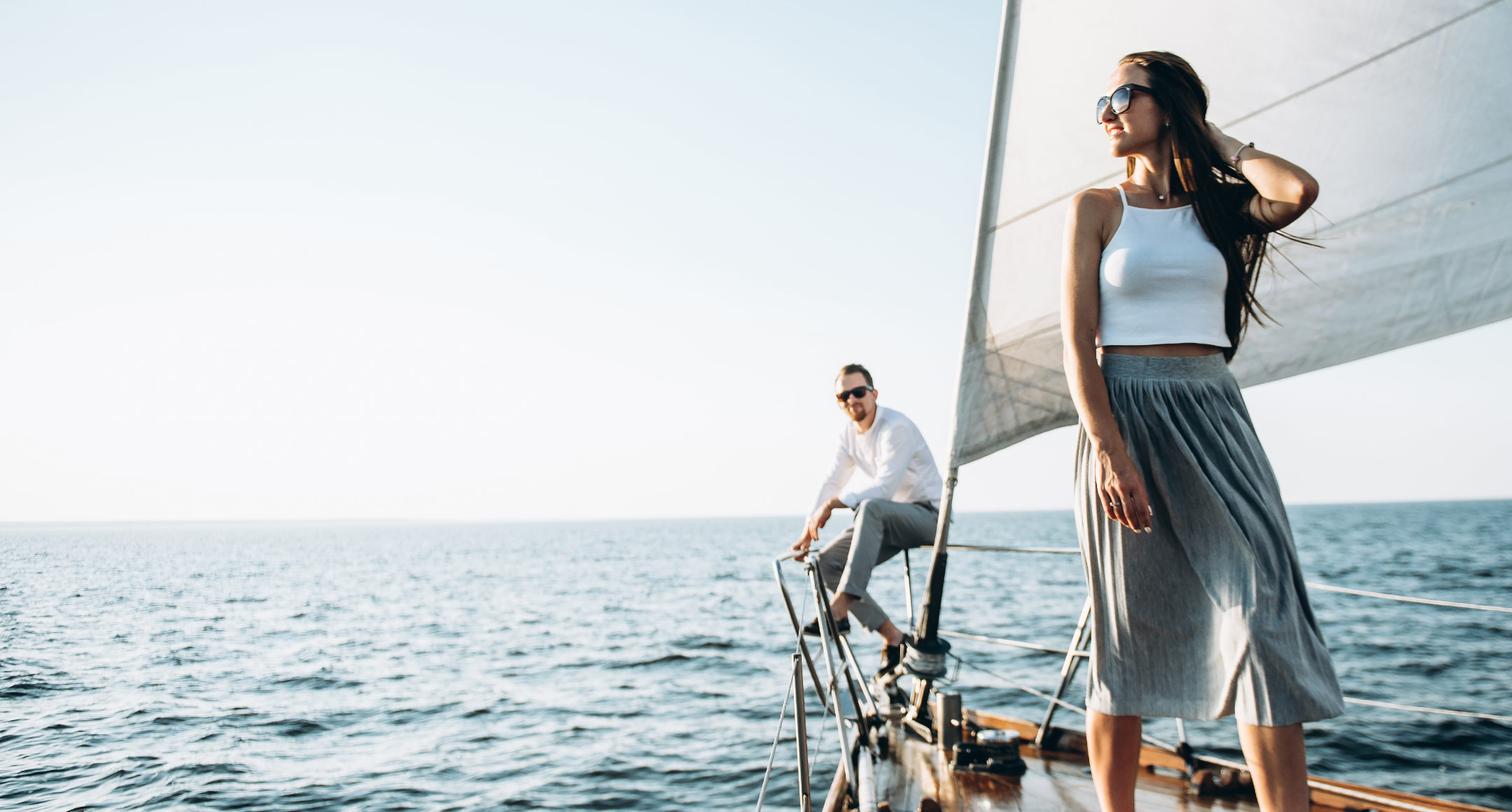 A couple standing on a sailboat in the ocean